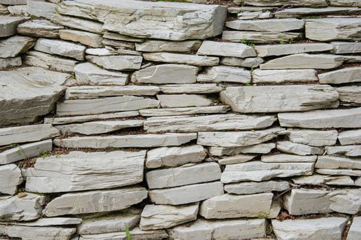 Sandstone Stone Wall Made of Many Blocks background. pattern of decorative white slate stone wall surface. old rock wall texture. modern granite style design decorative uneven cracked real stone surface