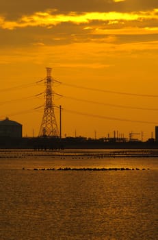 Coastal industrial estates and the hight voltage power line in the evening sunlight