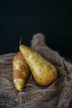 Still life with pears on burlap on a dark wooden photo. Pears Conference