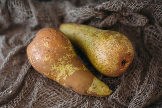 Still life with pears on burlap on a dark wooden photo. Pears Conference