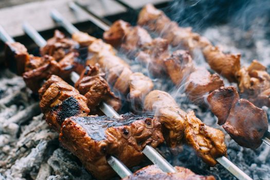 Skewers of pork ribs and chicken on skewers. Grilled meat. Cooking outdoors.