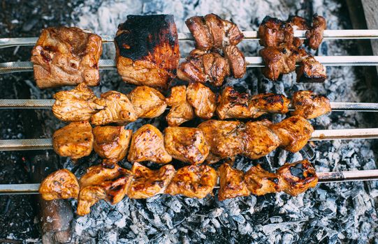 Chicken skewers on skewers on fire. Cooking meat outdoors in the open air.