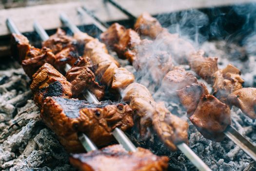 Skewers of pork ribs and chicken on skewers. Grilled meat. Cooking outdoors.