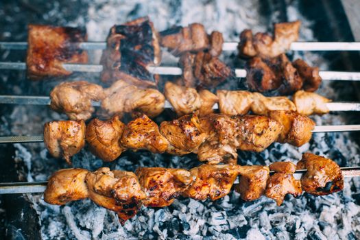 Chicken skewers on skewers on fire. Cooking meat outdoors in the open air.