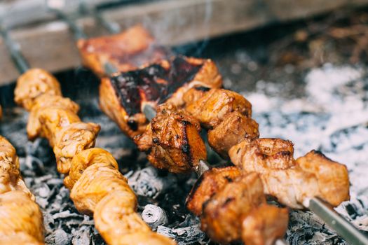 Chicken skewers on skewers on fire. Cooking meat outdoors in the open air.