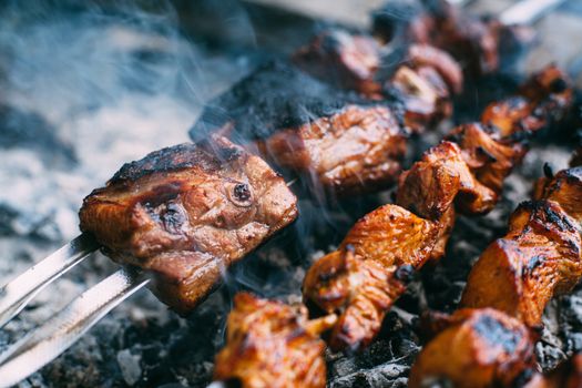 Skewers of pork ribs and chicken on skewers. Grilled meat. Cooking outdoors.