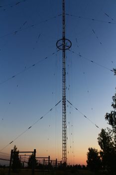 Radio and television tower on the background of the sunset and the moon.