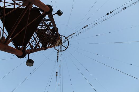 Photo of a television and radio tower from below against a blue sky. Abandoned tower