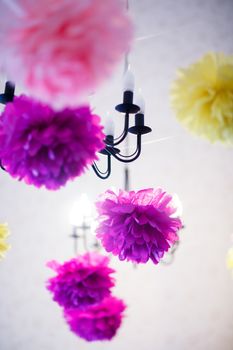 Ceiling decorated with paper pompoms for a baby's birthday