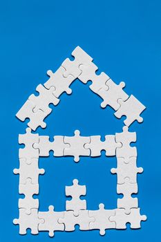 House made of puzzles. Modern house puzzle white pieces for concept design. Jigsaw Home, building, exterior. Puzzle construction renting, leasing, mortgage. House is made up of pieces of puzzles.