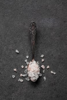 Spoon with Himalayan salt on a black table
