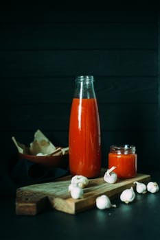 Tomato juice in a jar with a chapel on a wooden board