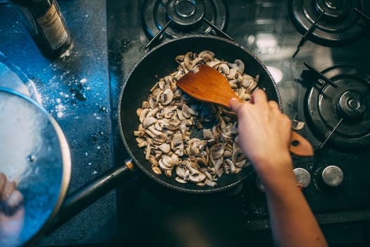 Cooking mushrooms in a pan. Stirring with a spatula.