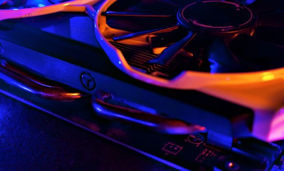 Graphics card in neon light. Cooling in a computer. Fan blade