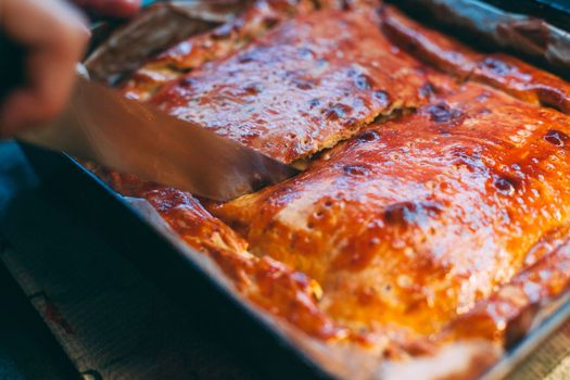 Slicing freshly baked cheese pie. Hands in the frame.