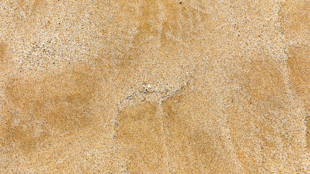 Sand surface and background. Sand Texture. Brown sand. Background from fine sand. Sand background. Closeup of sand pattern of a beach in the summer.