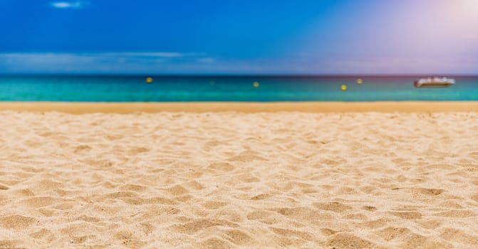 Soft wave of blue ocean on sandy tropical beach. Background of tropical paradise beach with golden sand, travel tourism panorama background concept. Sand and sea waves background.