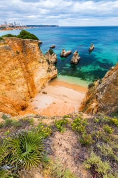 View of stunning beach with golden color rocks in Alvor town , Algarve, Portugal. View of cliff rocks on Alvor beach, Algarve region, Portugal.