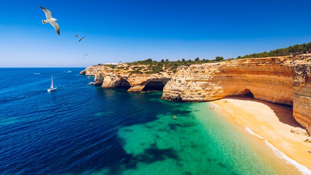 Corredoura Beach, sighted viewpoint on the trail of the Seven Suspended Valleys (Sete Vales Suspensos). Praia da Corredoura with flying seagulls near Benagil village, Algarve, Portugal.