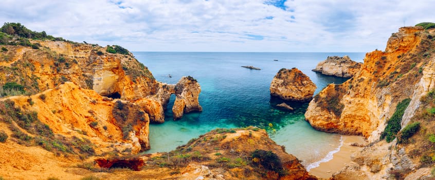 View of stunning beach with golden color rocks in Alvor town , Algarve, Portugal. View of cliff rocks on Alvor beach, Algarve region, Portugal.