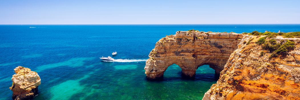 Natural caves at Marinha beach, Algarve Portugal. Rock cliff arches on Marinha beach and turquoise sea water on coast of Portugal in Algarve region. 