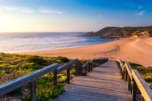 Wooden walkway to the beach Praia da Amoreira, District Aljezur, Algarve Portugal. Panorama from Amoreira beach in the Algarve Portugal. Beach and estuary of the Aljezur river, Praia da Amoreira.