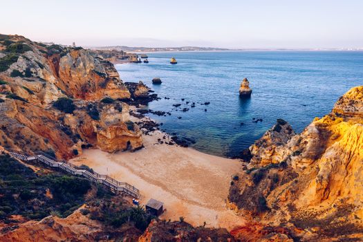 Camilo Beach (Praia do Camilo) at Algarve, Portugal with turquoise sea in background. Wooden footbridge to beach Praia do Camilo, Portugal. Wonderful view of Camilo Beach in Lagos, Algarve, Portugal.