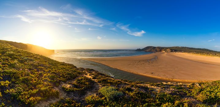 Wooden walkway to the beach Praia da Amoreira, District Aljezur, Algarve Portugal. Panorama from Amoreira beach in the Algarve Portugal. Beach and estuary of the Aljezur river, Praia da Amoreira.