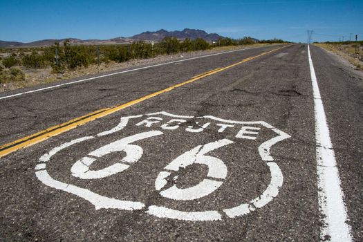 Long US road with a Route 66 sign painted on it