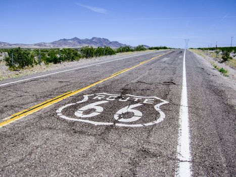 Long US road with a Route 66 sign painted on it