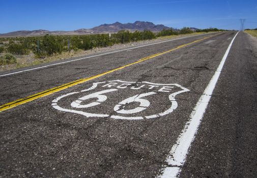 Long US road with a Route 66 sign painted on it