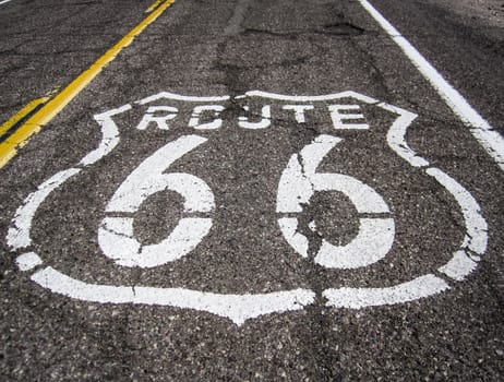 Long US road with a Route 66 sign painted on it