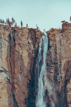 Beautiful Bridalveil Falls cut into the Granite of Yosemite National Park. Orange and tela style.