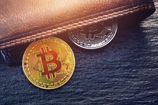 Bitcoin in brown leather wallet. Bitcoin, modern virtual cryptocurrency. Profit from mining crypto currencies. Bitcoin gold coins with wallet, close-up. Virtual cryptocurrency concept.