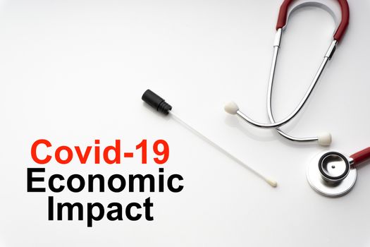 COVID-19 ECONOMIC IMPACT text with stethoscope and medical swab on white background. Covid or Coronavirus Concept 