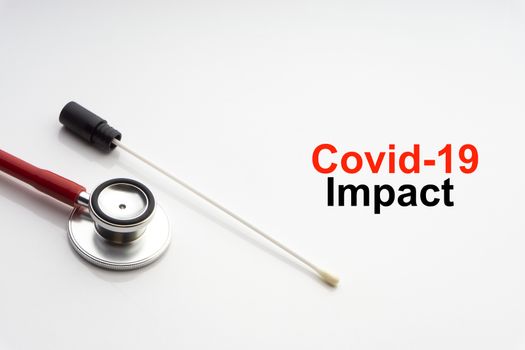 COVID-19 IMPACT text with stethoscope and medical swab on white background. Covid or Coronavirus Concept 