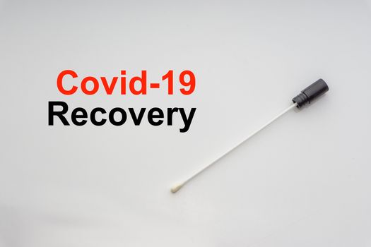 COVID-19 RECOVERY text with medical swab on white background. Covid or Coronavirus Concept 