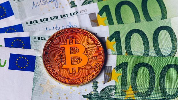 Bitcoin cryptocurrency (crypto currency) over Euro money. Golden Bitcoin symbol. Bitcoin (BTC) cryptocurrency.