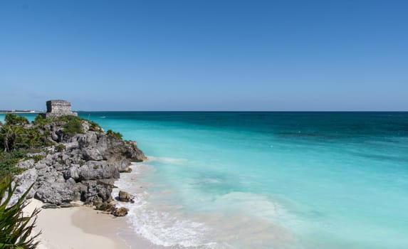 Beautiful beach with turquoise water in Tulum Mexico, Mayan ruins on top of the cliff.