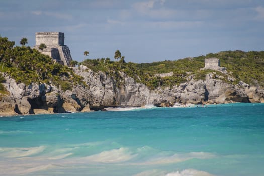 Beautiful beach with turquoise water in Tulum Mexico, Mayan ruins on top of the cliff.