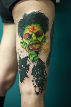 Coloured Tattoo with green face painted in a leg