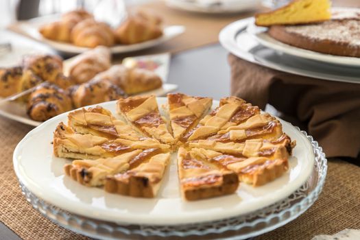 Selection self service continental breakfast buffet display, catering or brunch table food buffet filled with homemade cakes and delicious croissants in a hotel or restaurant setting.