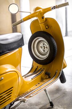 Yellow scooter parked in the garage.