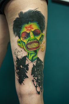 Coloured Tattoo with green face painted in a leg