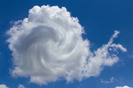 A cloud in the blue sky with the shape of a snail.