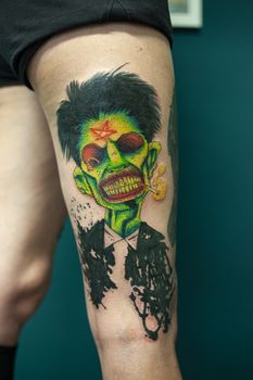 Coloured Tattoo with green face painted in a leg