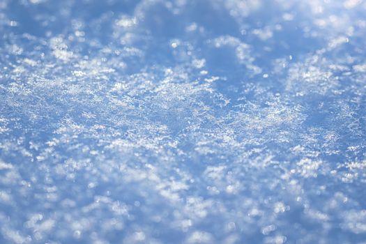 Macro background of fresh snowflake texture on a blur.