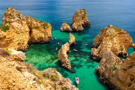 Panoramic view, Ponta da Piedade near Lagos in Algarve, Portugal. Cliff rocks and tourist boat on sea at Ponta da Piedade, Algarve region, Portugal. Ponta da Piedade, Algarve region, Portugal.
