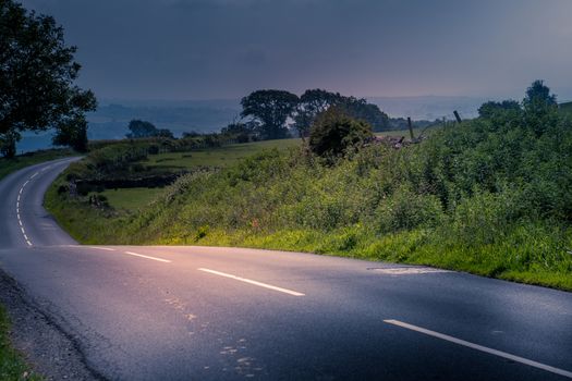 curved road in middle of rural Engalnd with dry stone walls