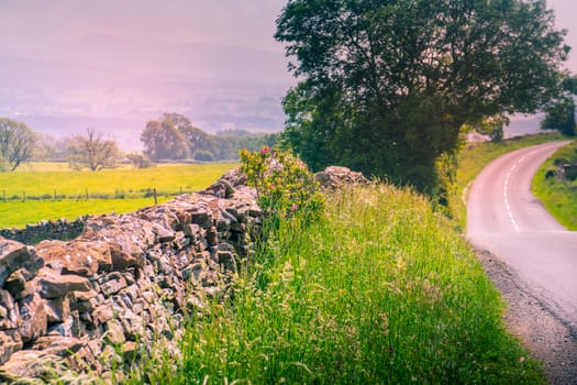 curved road in middle of rural Engalnd with dry stone walls